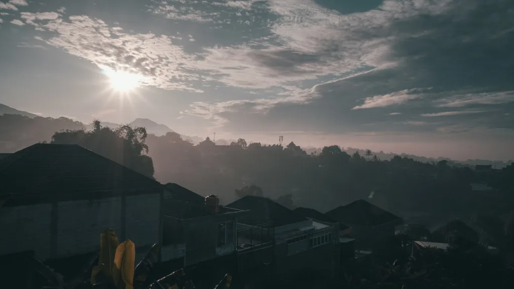 Matahari pagi menembus awan di atas lembah Bandung berkabut dilihat dari Villa Yucca