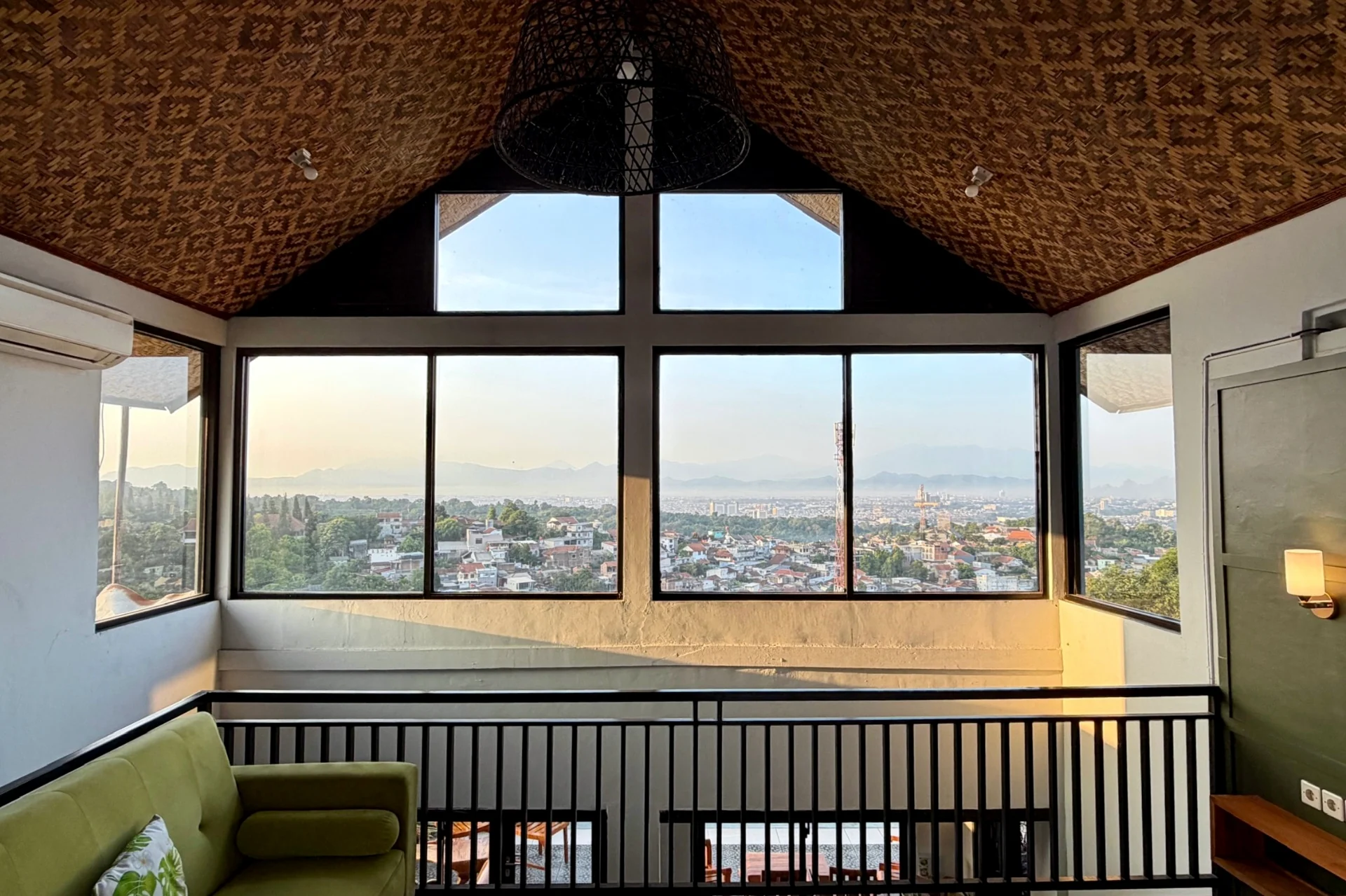Mezzanine Kamar 1 dengan plafon rotan beratap miring membingkai pemandangan Bandung dan gunung