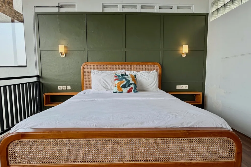 Kamar 1 di lantai mezzanine Villa Yucca dengan plafon kayu beratap miring dan pemandangan kota Bandung
